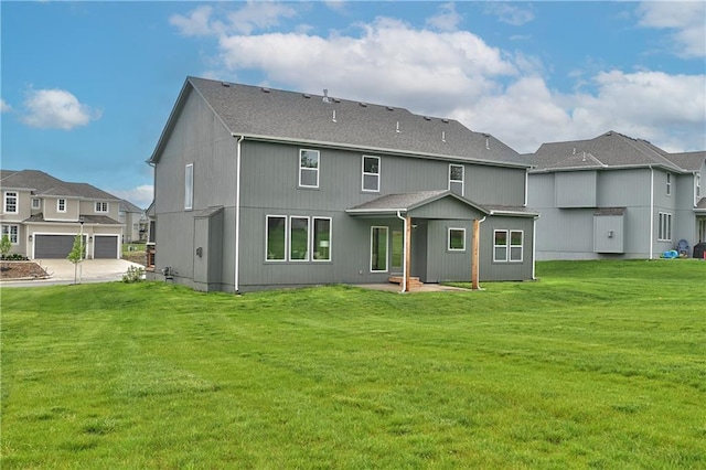 back of property featuring a garage and a lawn