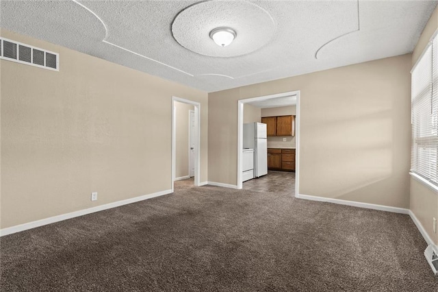 unfurnished room with carpet flooring and a textured ceiling