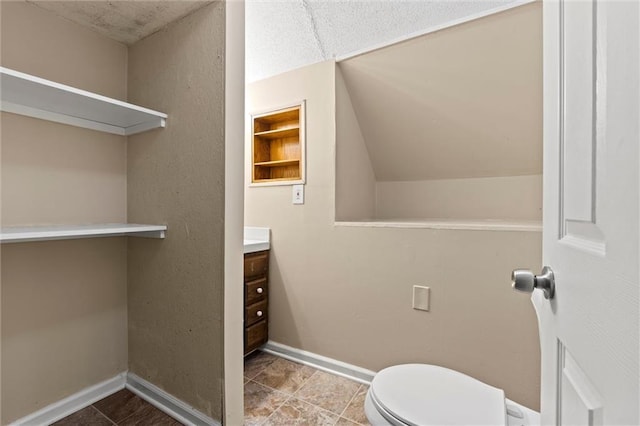 bathroom with vanity, built in features, and toilet