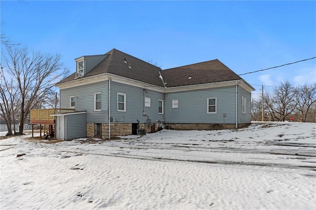 view of snow covered back of property