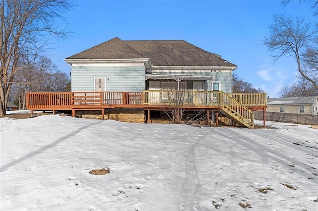 snow covered house with a wooden deck