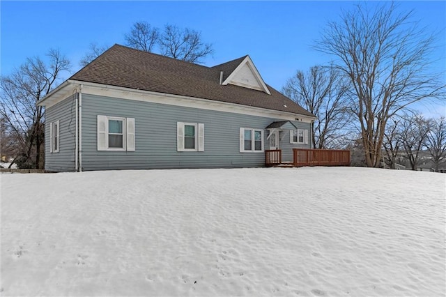 snow covered rear of property featuring a deck