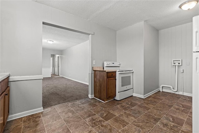 kitchen featuring dark carpet, white electric range, a textured ceiling, and wooden walls