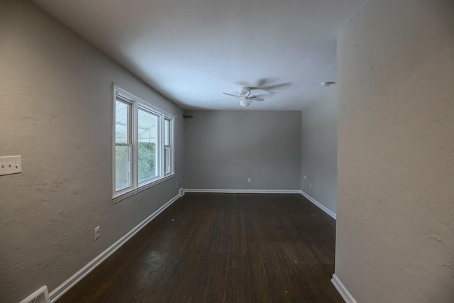 empty room with dark hardwood / wood-style floors and ceiling fan