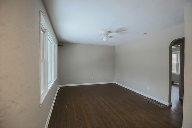 empty room with ceiling fan and dark hardwood / wood-style flooring