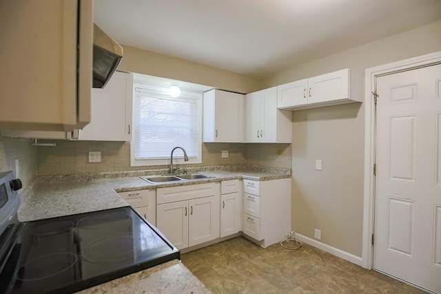 kitchen featuring tasteful backsplash, electric stove, white cabinets, and a sink