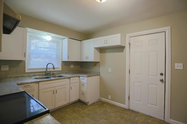 kitchen with backsplash, white cabinets, a sink, black range with electric cooktop, and baseboards