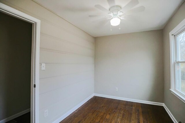 unfurnished room featuring dark wood finished floors, baseboards, and ceiling fan