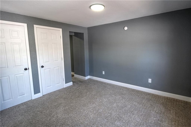 unfurnished bedroom with multiple closets and carpet