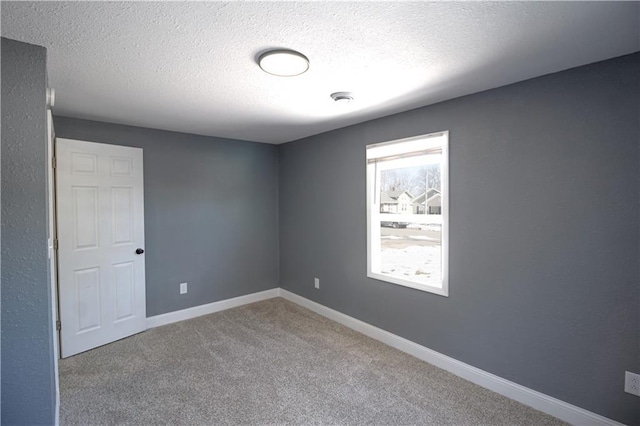 unfurnished room with carpet flooring and a textured ceiling