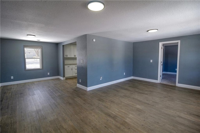 empty room with dark hardwood / wood-style flooring and a textured ceiling