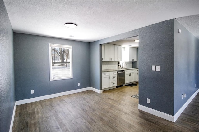 kitchen featuring dark hardwood / wood-style floors, white cabinetry, dishwasher, backsplash, and a textured ceiling