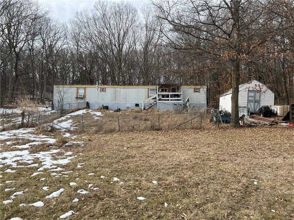 view of front of property featuring a shed