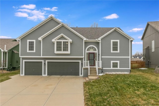 raised ranch featuring a garage and a front yard