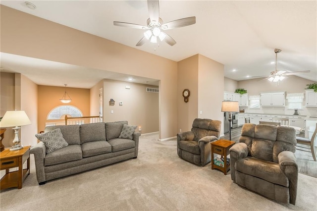 carpeted living room featuring ceiling fan and vaulted ceiling