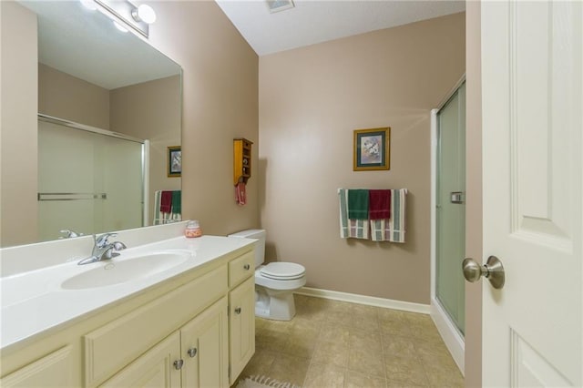 bathroom featuring vanity, a shower with door, and toilet