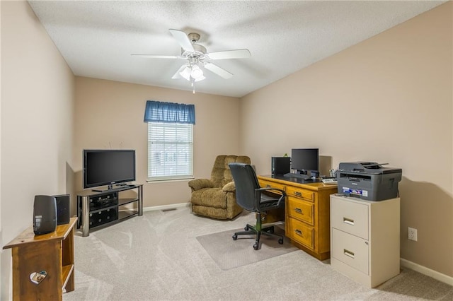 home office featuring ceiling fan, light colored carpet, and a textured ceiling