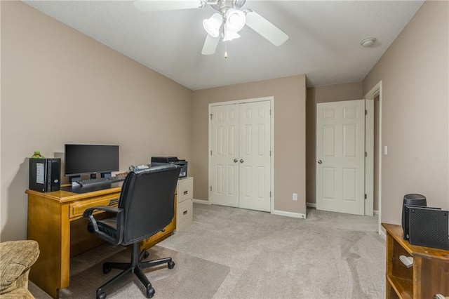 carpeted office space with ceiling fan