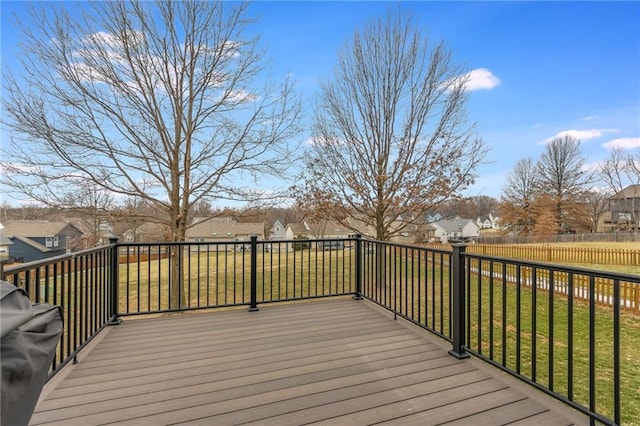 wooden terrace featuring a grill and a lawn