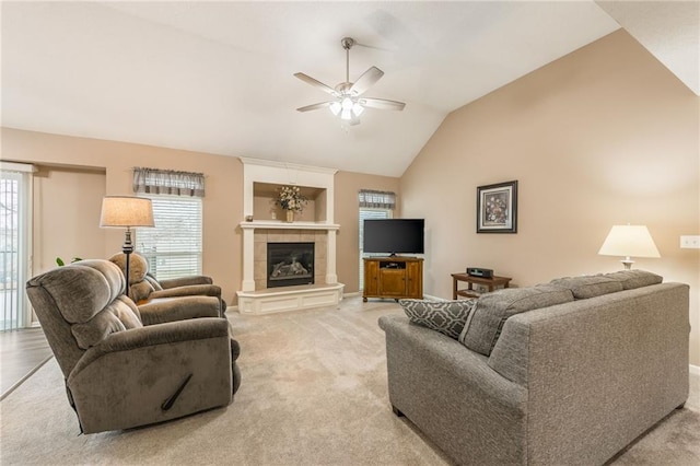 living room with light carpet, a fireplace, vaulted ceiling, and ceiling fan