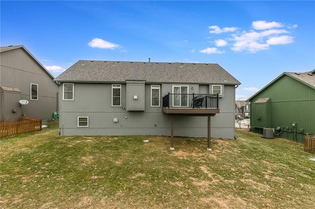 back of property with central AC and a lawn