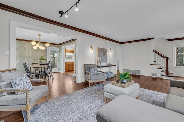 living room featuring crown molding, hardwood / wood-style flooring, track lighting, and a healthy amount of sunlight