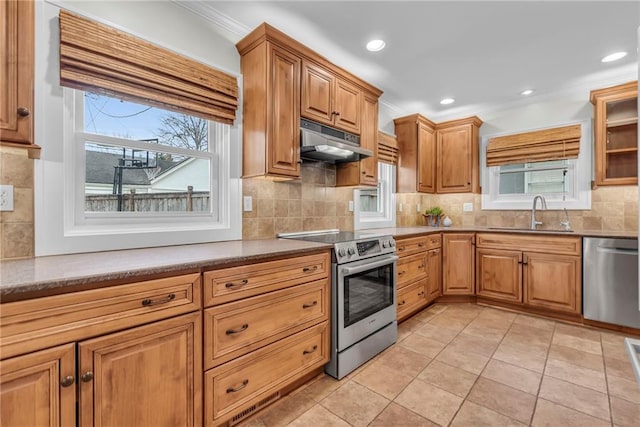 kitchen with light tile patterned flooring, sink, crown molding, stainless steel appliances, and decorative backsplash