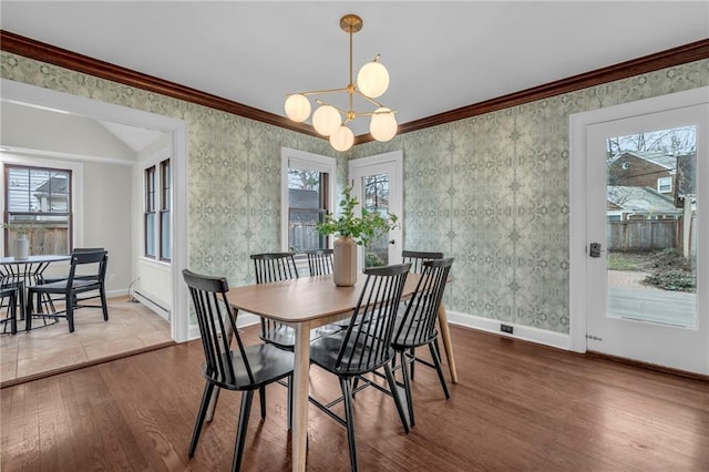 dining area featuring ornamental molding, wood-type flooring, and a wealth of natural light