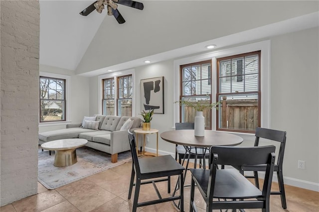 tiled dining area featuring ceiling fan, plenty of natural light, and high vaulted ceiling