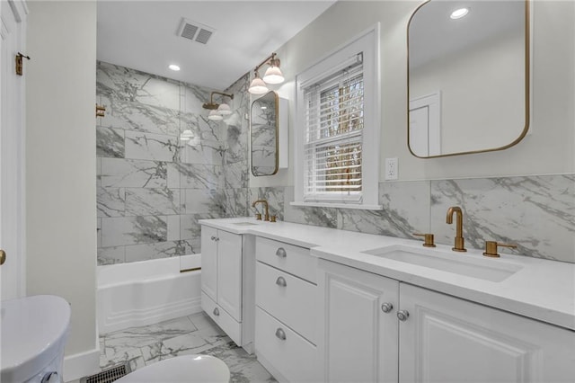 full bathroom with tiled shower / bath combo, vanity, and toilet