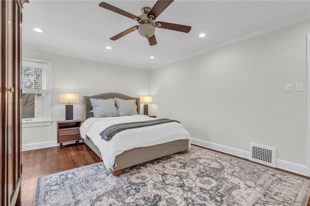 bedroom featuring crown molding, dark wood-type flooring, and ceiling fan