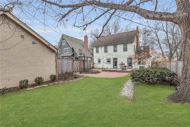 rear view of property with a lawn and a patio area