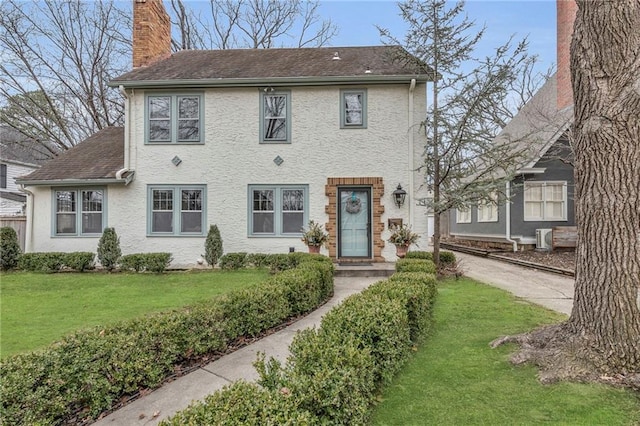 colonial house featuring a front lawn