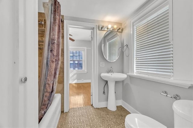 bathroom featuring tile patterned floors, shower / bath combo with shower curtain, and toilet