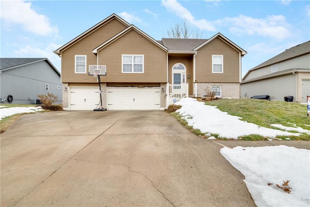 split foyer home featuring a garage and a front lawn