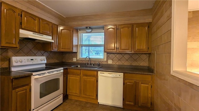 kitchen featuring sink, white appliances, decorative backsplash, and dark tile patterned floors