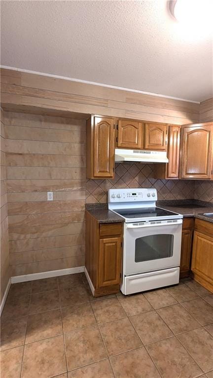 kitchen featuring tasteful backsplash, light tile patterned flooring, a textured ceiling, and electric range