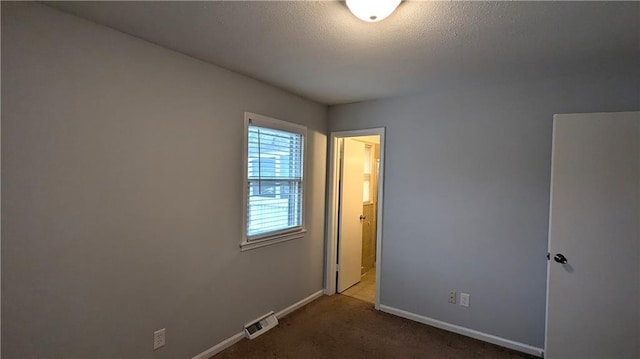 carpeted spare room with a textured ceiling