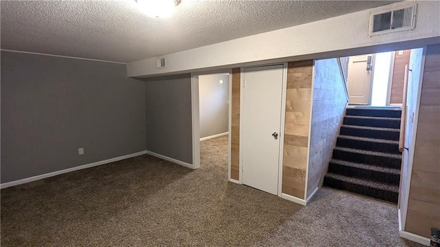 basement featuring carpet and a textured ceiling