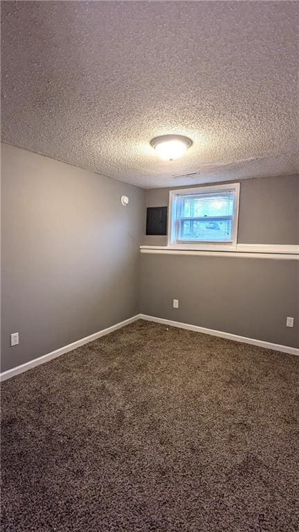 spare room featuring carpet floors and a textured ceiling