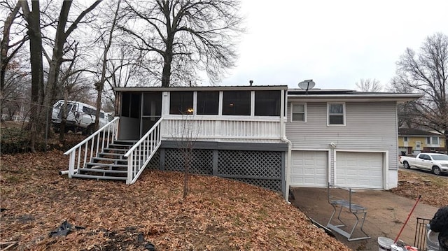 back of property featuring a garage and a sunroom