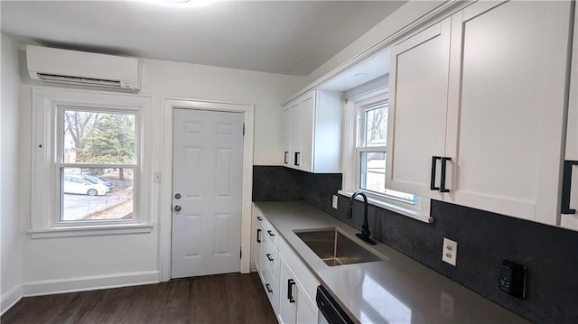 kitchen with dark hardwood / wood-style flooring, sink, a wall mounted AC, and white cabinets