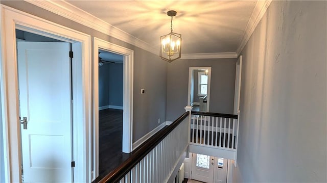 staircase with crown molding and a chandelier