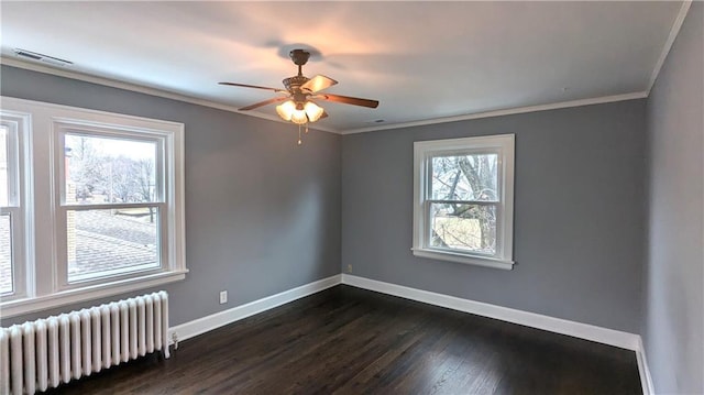 empty room featuring crown molding, plenty of natural light, dark hardwood / wood-style floors, and radiator heating unit