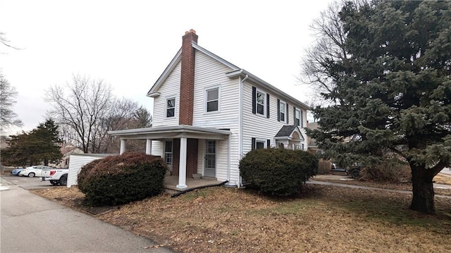 view of side of property with a porch and a yard