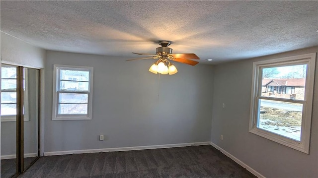 carpeted empty room with a textured ceiling and ceiling fan