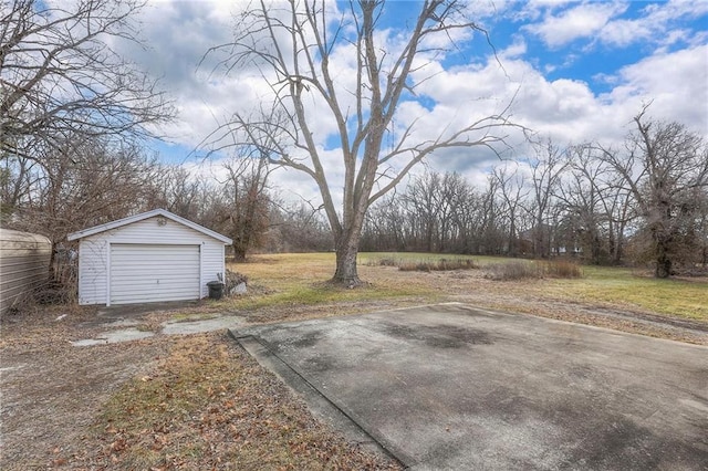 view of yard featuring a garage and an outbuilding