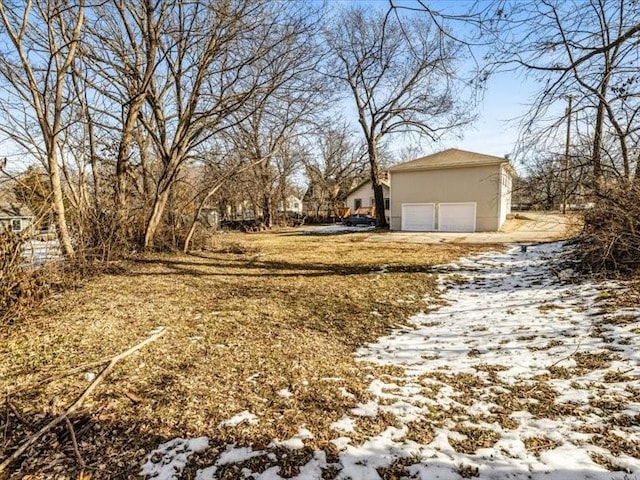 snowy yard with a garage