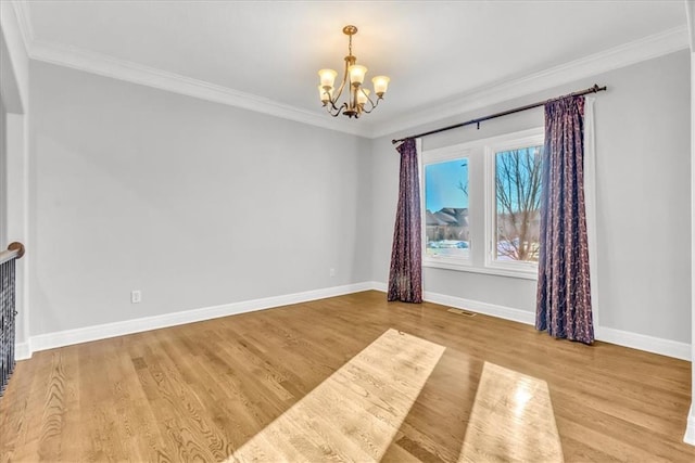 empty room with crown molding, a notable chandelier, and light wood-type flooring