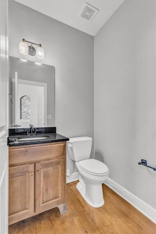 bathroom featuring vanity, hardwood / wood-style floors, and toilet